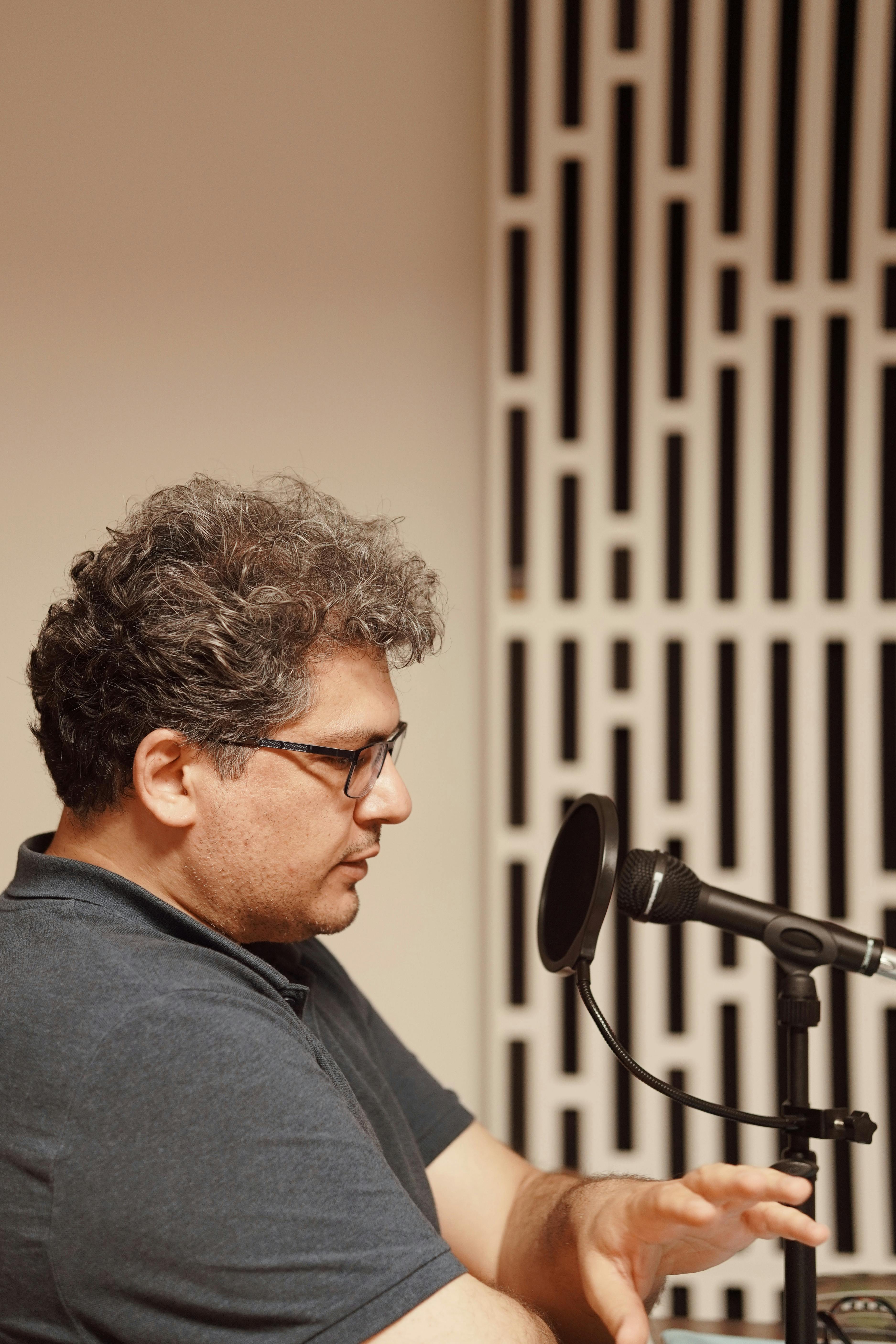 Professional radio presenter speaking into a microphone during a live session in a studio.