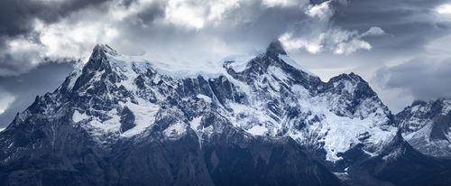 Free Majestic snowcapped mountains captured under dramatic cloudy skies, highlighting natural beauty. Stock Photo