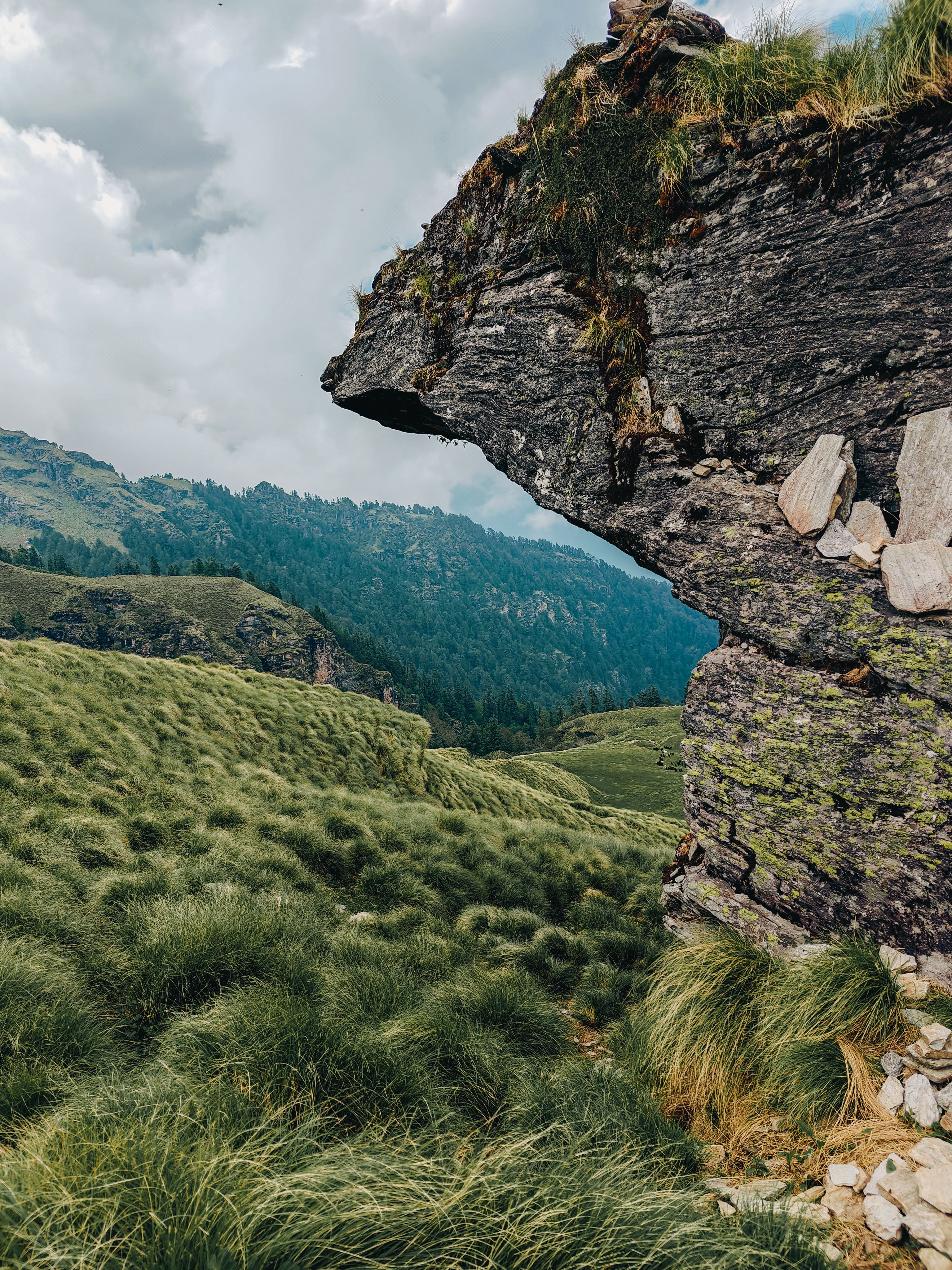 A rock formation in the middle of a grassy field · Free Stock Photo