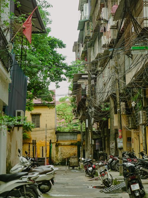 Free A busy urban alleyway filled with scooters and tangled electrical cables. Stock Photo
