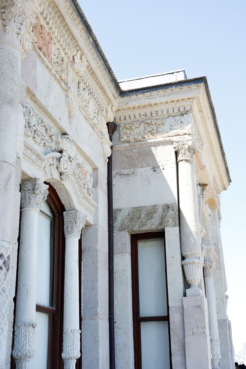 Free Close-up of a classical building facade with ornate architectural details on a sunny day. Stock Photo