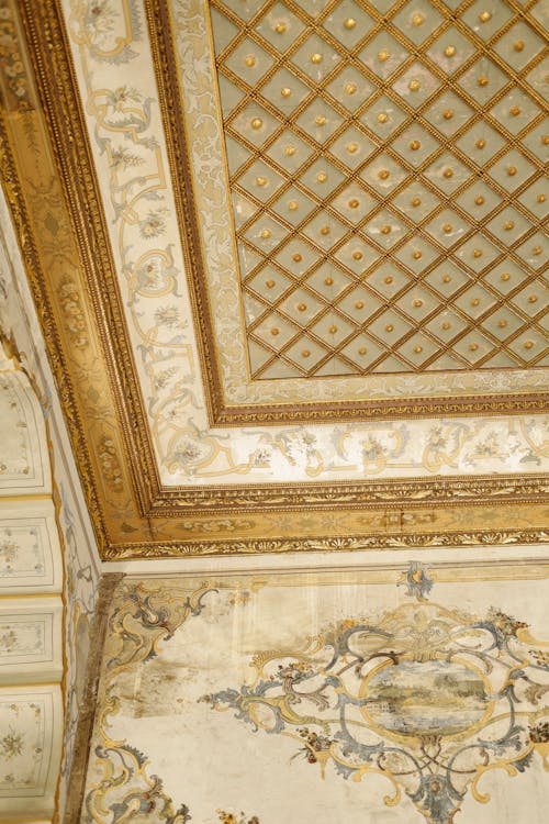 A ceiling with ornate designs and gold paint