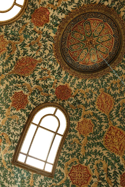 A ceiling with ornate designs and windows