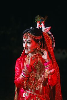 A stunning portrait of an Indian woman in a red sari adorned with traditional gold jewelry and ornaments.