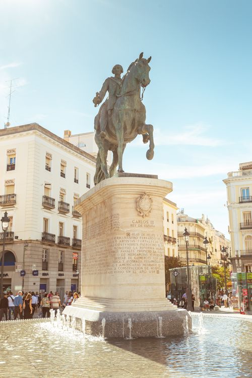 Free The iconic Carlos III statue in Madrid's bustling Puerta del Sol under a clear sky. Stock Photo
