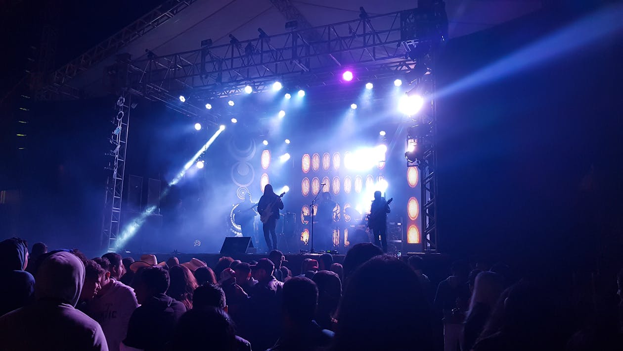 Photo of Band Performing to Crowd of People at a Concert