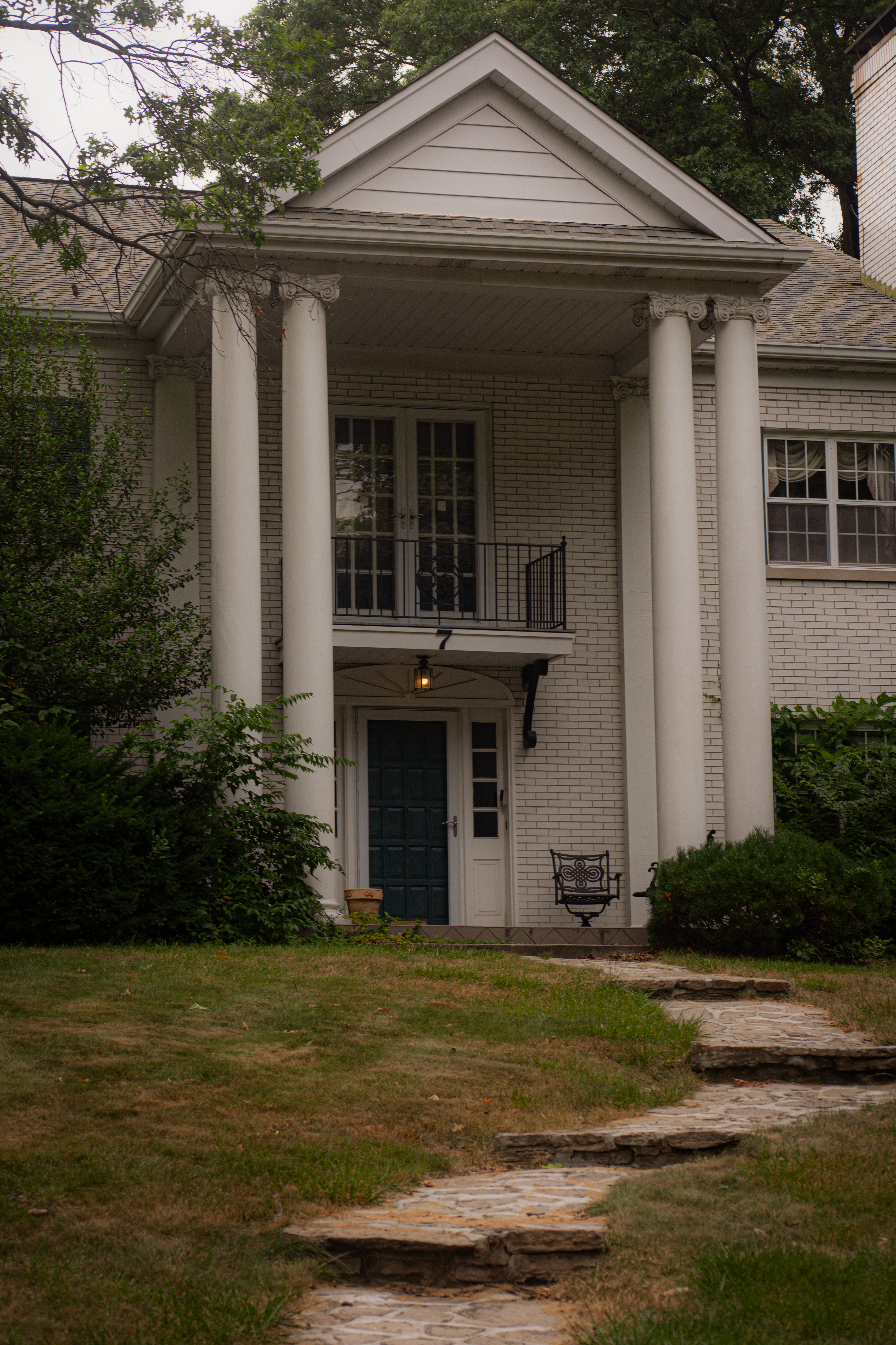 Darkened photo of a stately colonial home with tall front columns