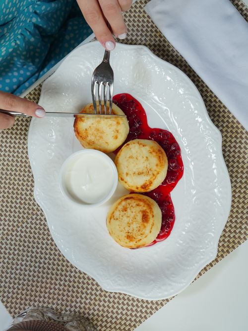 Free Top view of cheese pancakes with berry sauce and cream on a dining table. Stock Photo