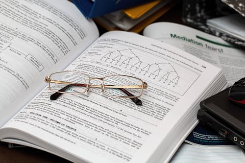 Free Eyeglasses on an Opened Book Stock Photo