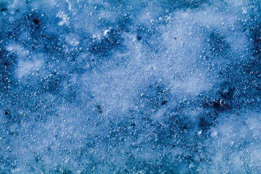 特写镜头捕捉到带有气泡的冰冷纹理，呈现出冰冻表面的冬日感觉