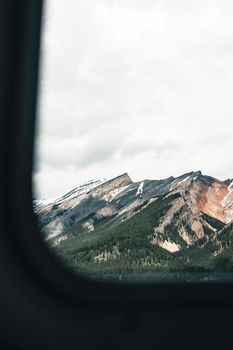 A breathtaking view of snow-capped mountains through a window in Banff National Park, Canada.