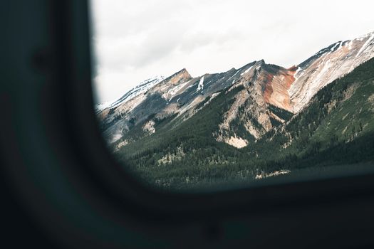 Breathtaking view of Banff's rugged mountains captured through an airplane window, showcasing natural beauty.