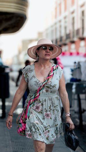 Woman in a floral dress walking a sunlit city street. Photo by Brian Jiz on Pexels.