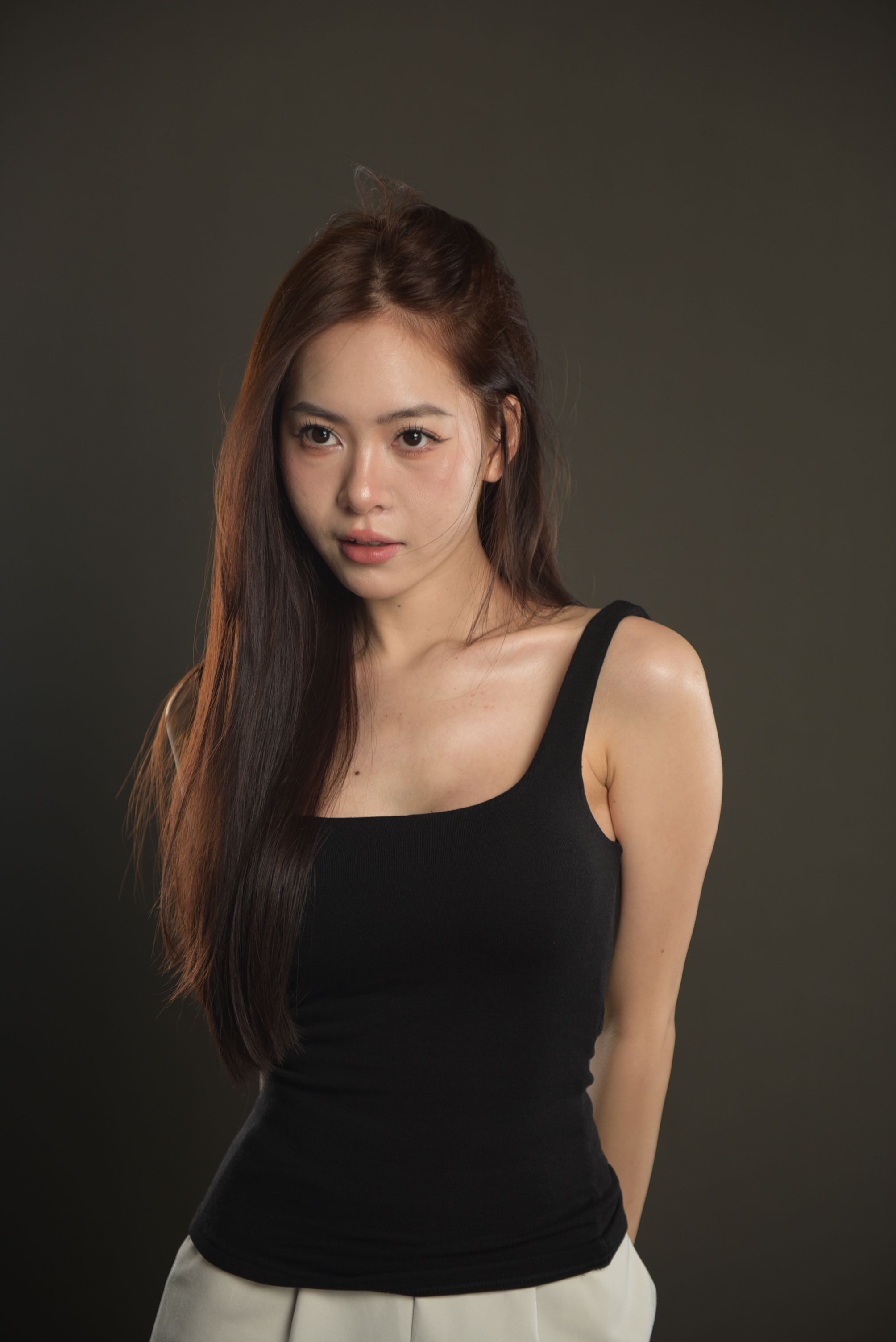 Portrait of a young woman posing elegantly indoors, showcasing fashion and style.