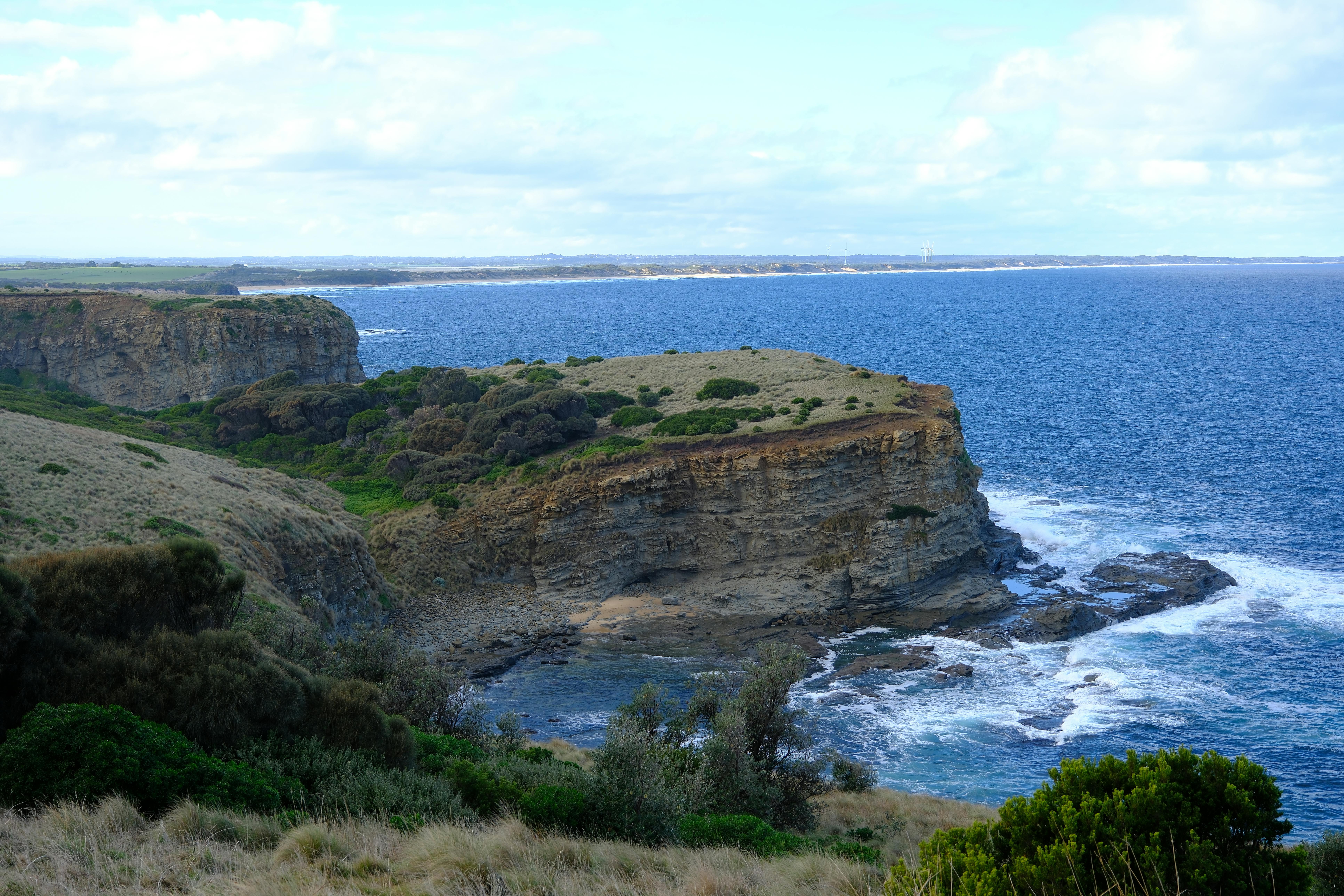 Breathtaking view of cliffs and ocean waves on a calm summer day.