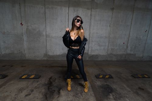 Free Fashionable woman in black attire posing confidently in an urban setting. Stock Photo