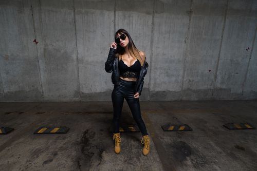 Free Stylish woman in black leather posing confidently in an urban parking lot. Stock Photo