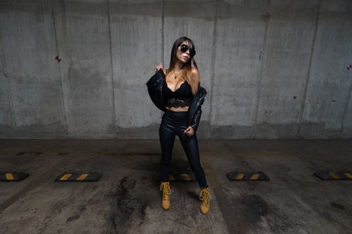 Free Fashionable woman posing in a leather outfit in an urban parking lot, Mexico City. Stock Photo