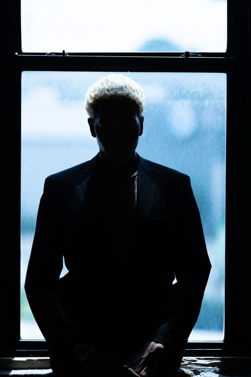 Free Dramatic silhouette of a person standing by a window in Chicago, emphasizing light and shadow. Stock Photo