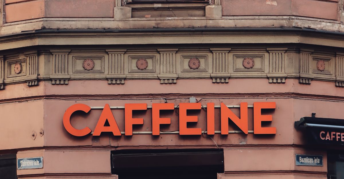 Building Facade with a Caffeine Sign · Free Stock Photo