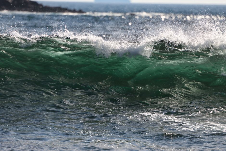 Dramatic green ocean wave crashing on Matosinhos beach, Portugal, showcasing nature's power.