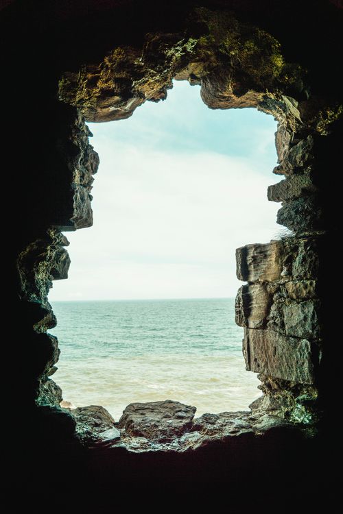 Free Dramatic seascape visible through the ruins of an ancient stone structure. Stock Photo