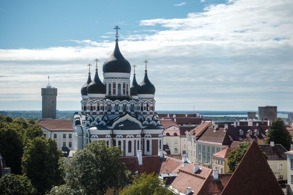 Modern 5G network tower against a city skyline in Estonia, symbolizing fast internet speeds.