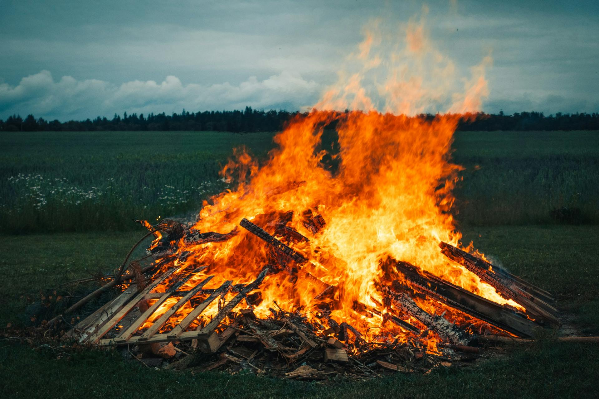 Large Bonfire with Wooden Pallets on Grassland