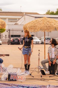 A band performing outdoors with straw umbrellas and musical instruments.