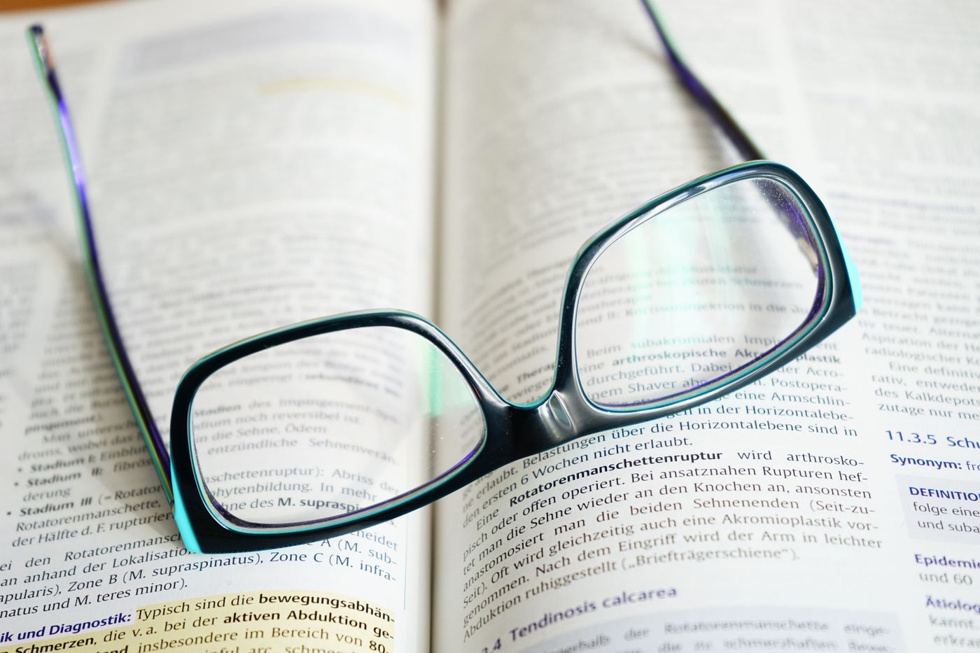 Reading glasses resting on an open textbook