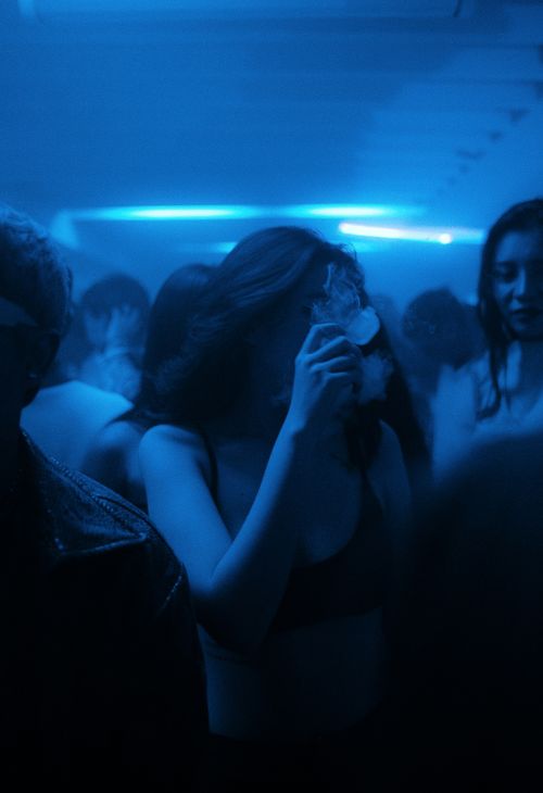 Free Captivating image of a party with blue lights and energetic young adults dancing. Stock Photo