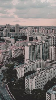 Drone shot capturing vibrant cityscape and residential buildings in Singapore.
