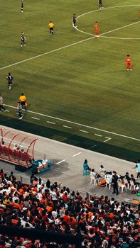 High-angle view of a vibrant soccer match capturing players and fans at Singapore stadium.