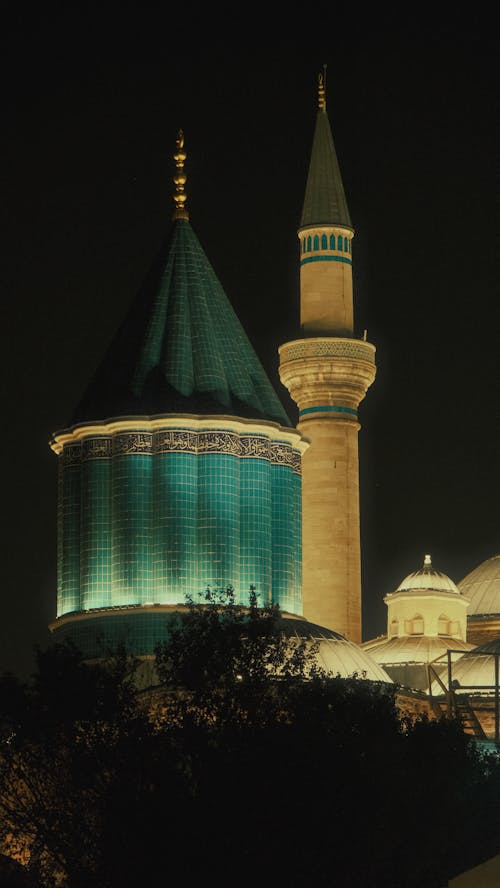 A night view of a mosque with green lights
