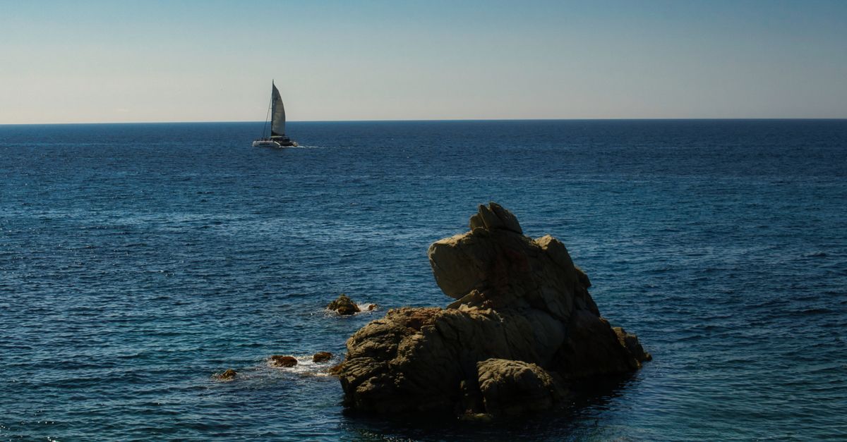 Sailboat and Rocks on Sea · Free Stock Photo