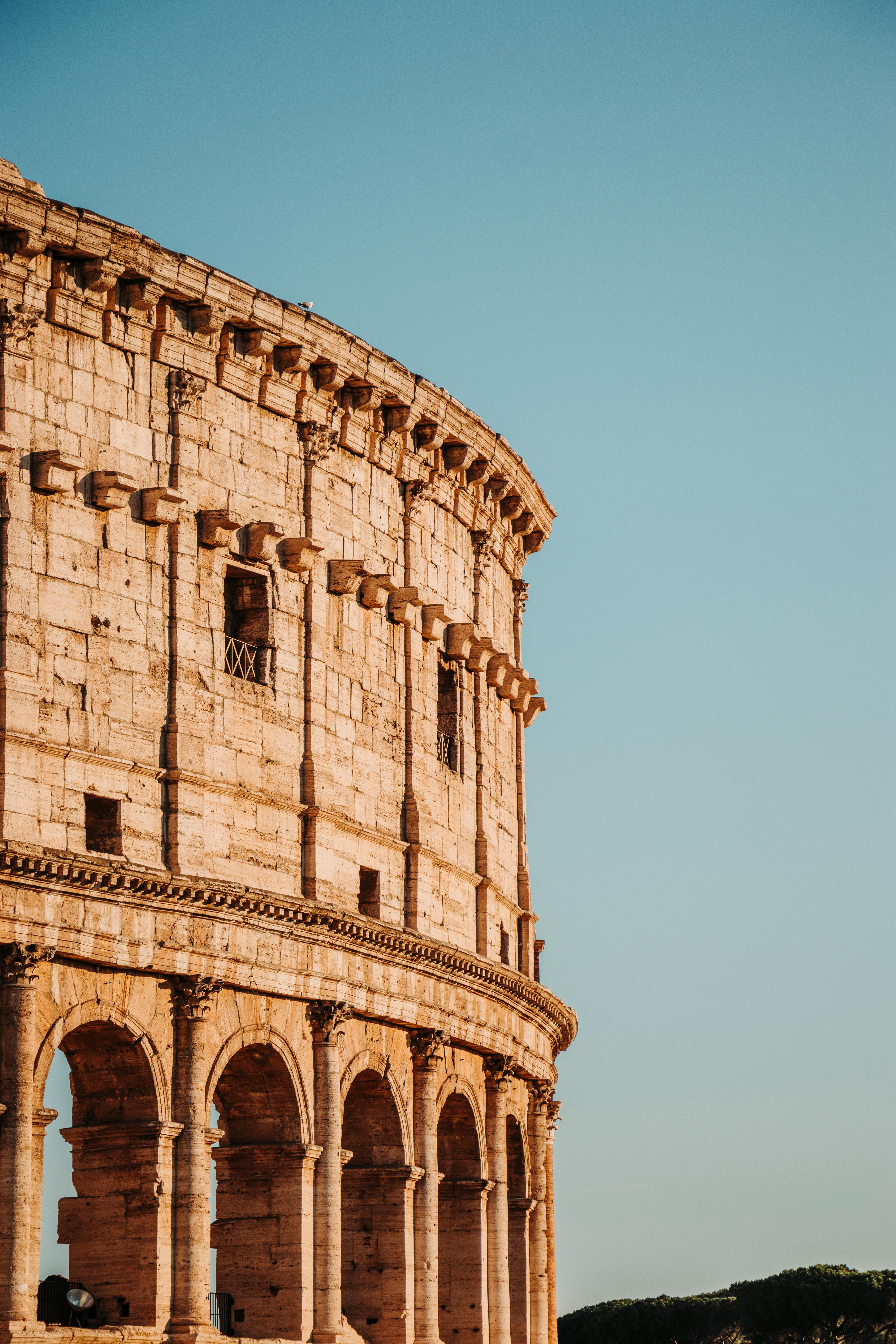 Free Capture of the historic Roman Colosseum with its iconic arched windows at sunrise. Stock Photo