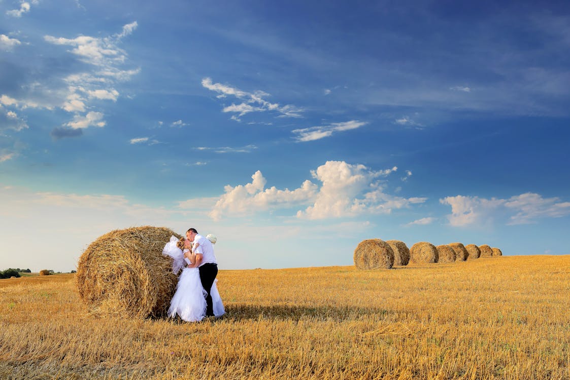 Free Photo of Couple Kissing Beside Hay Roll Stock Photo