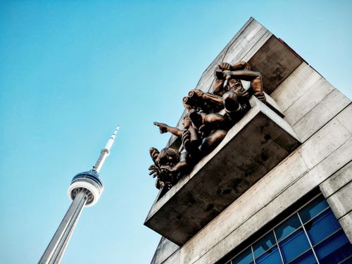 Free Low angle view of CN Tower and sculptures with a clear blue sky in Toronto, Canada. Stock Photo