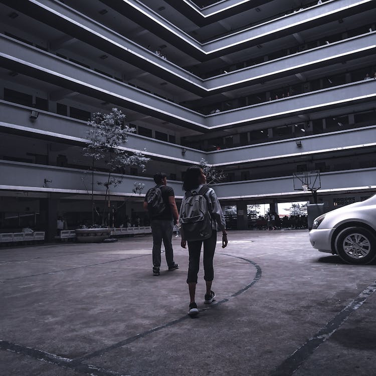 Photo Of Man And Woman Walking In Campus