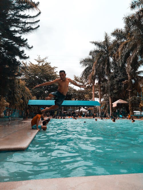 Photo of a man jumping into a swimming pool
