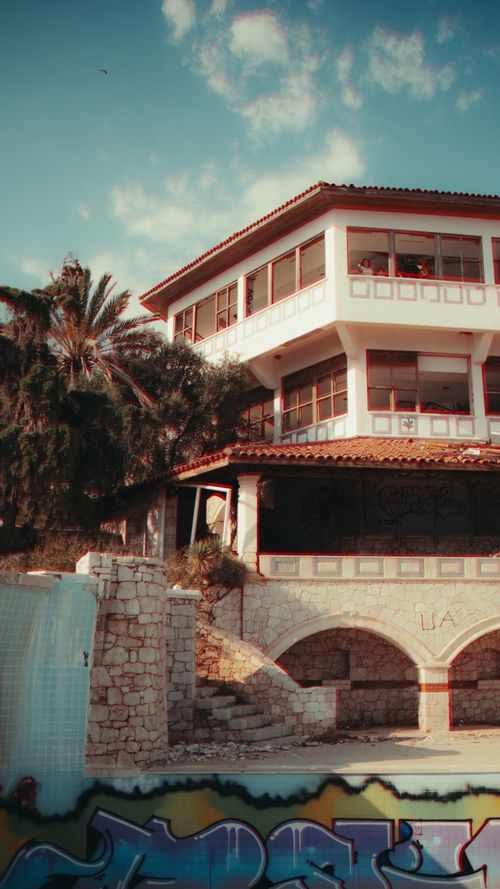 Free A historic building with tropical palm trees and graffiti in an urban setting. Stock Photo