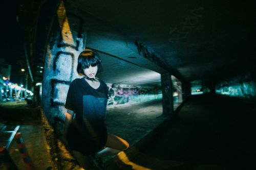 Free Fashionable young woman in street style at night with a spiked collar. Captivating urban portrait. Stock Photo