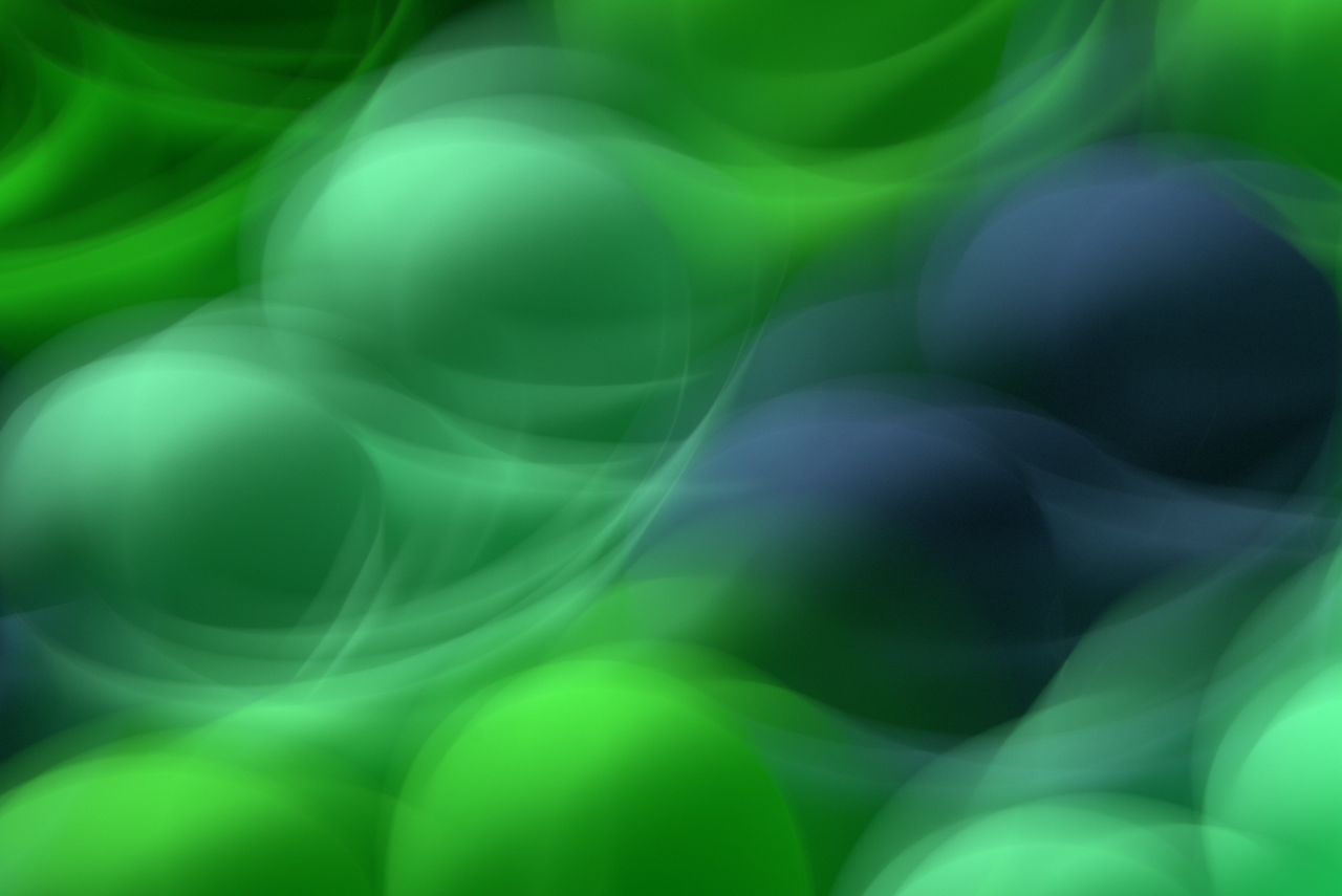 blurred abstract image of swirling green and blue shapes with a dreamy