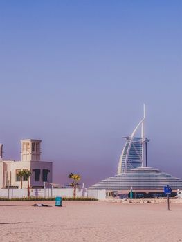 Capture of Burj Al Arab with clear skies from Dubai's sandy beach, highlighting iconic architecture.