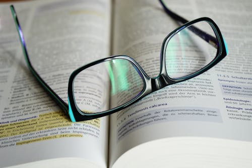Free Eyeglasses With Black Frames on Book Stock Photo