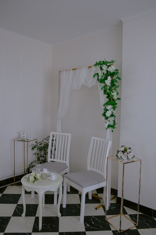 Free Beautiful white wedding decor with floral accents and elegant seating arrangement indoors. Stock Photo
