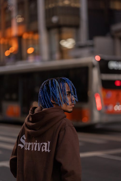 A person with blue hair and a hoodie