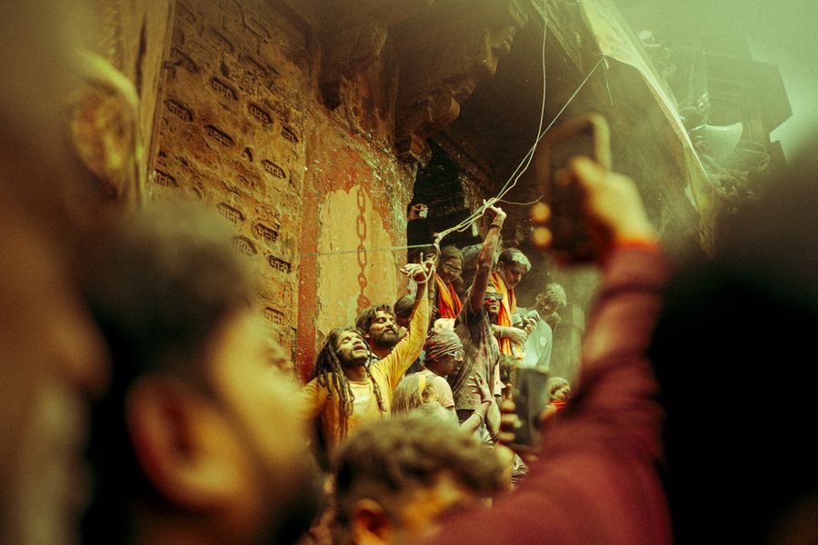 Vibrant festival scene with people celebrating Holi in Varanasi, India.