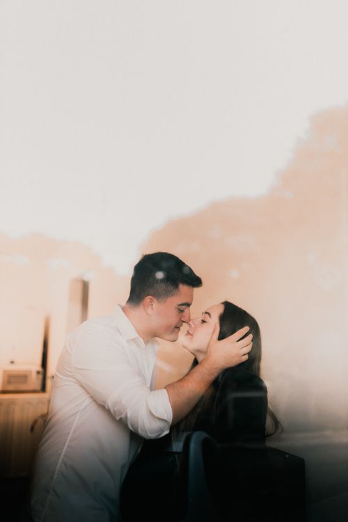 Free A loving couple shares an intimate kiss while embracing softly indoors, capturing a moment of affection. Stock Photo