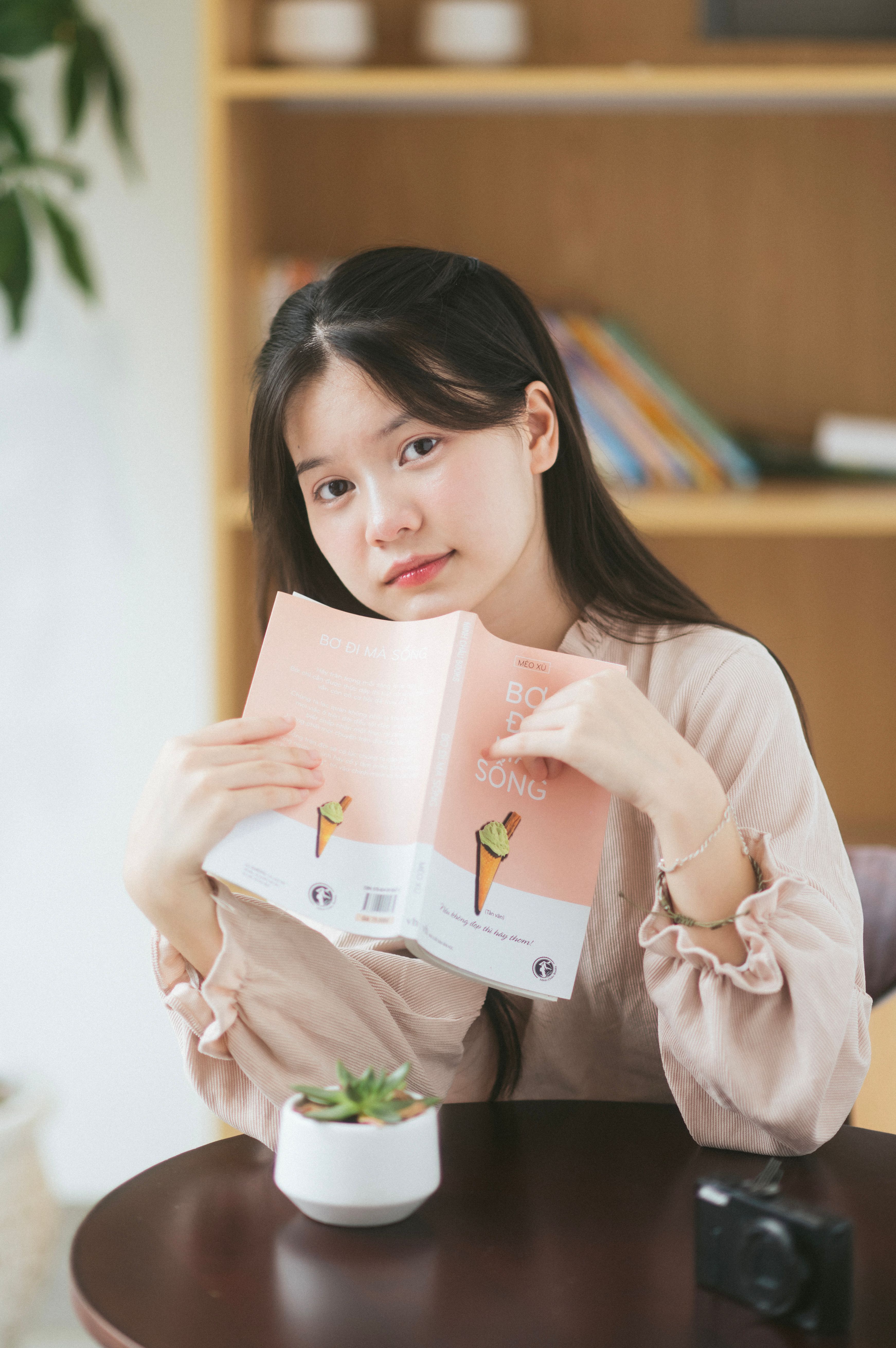 A young woman in Lạng Sơn, Vietnam reads a book, creating a warm and cozy atmosphere indoors.